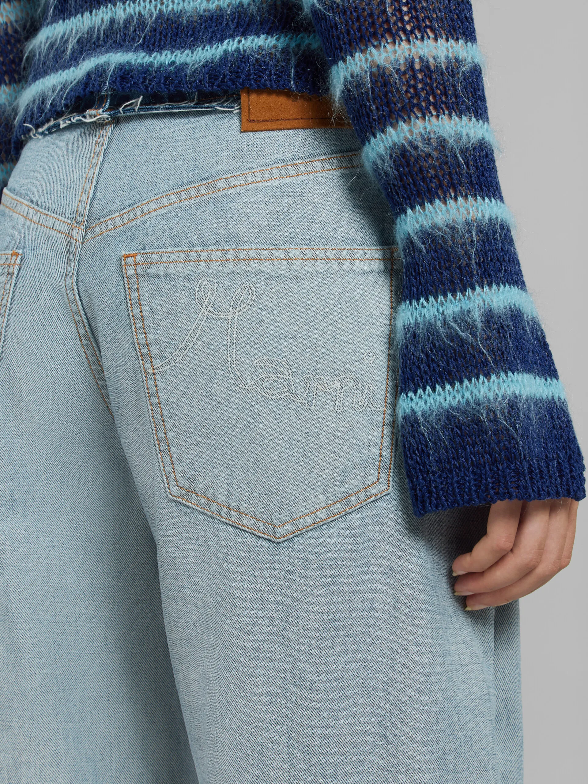 Jeans carrot in denim blu con cuciture interne a vista